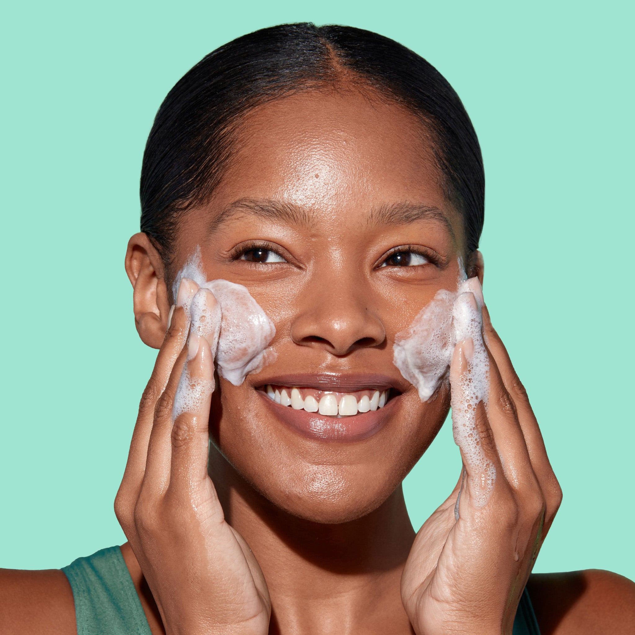 Girl cleansing her face with Miracle Clear Exfoliating Cleanser